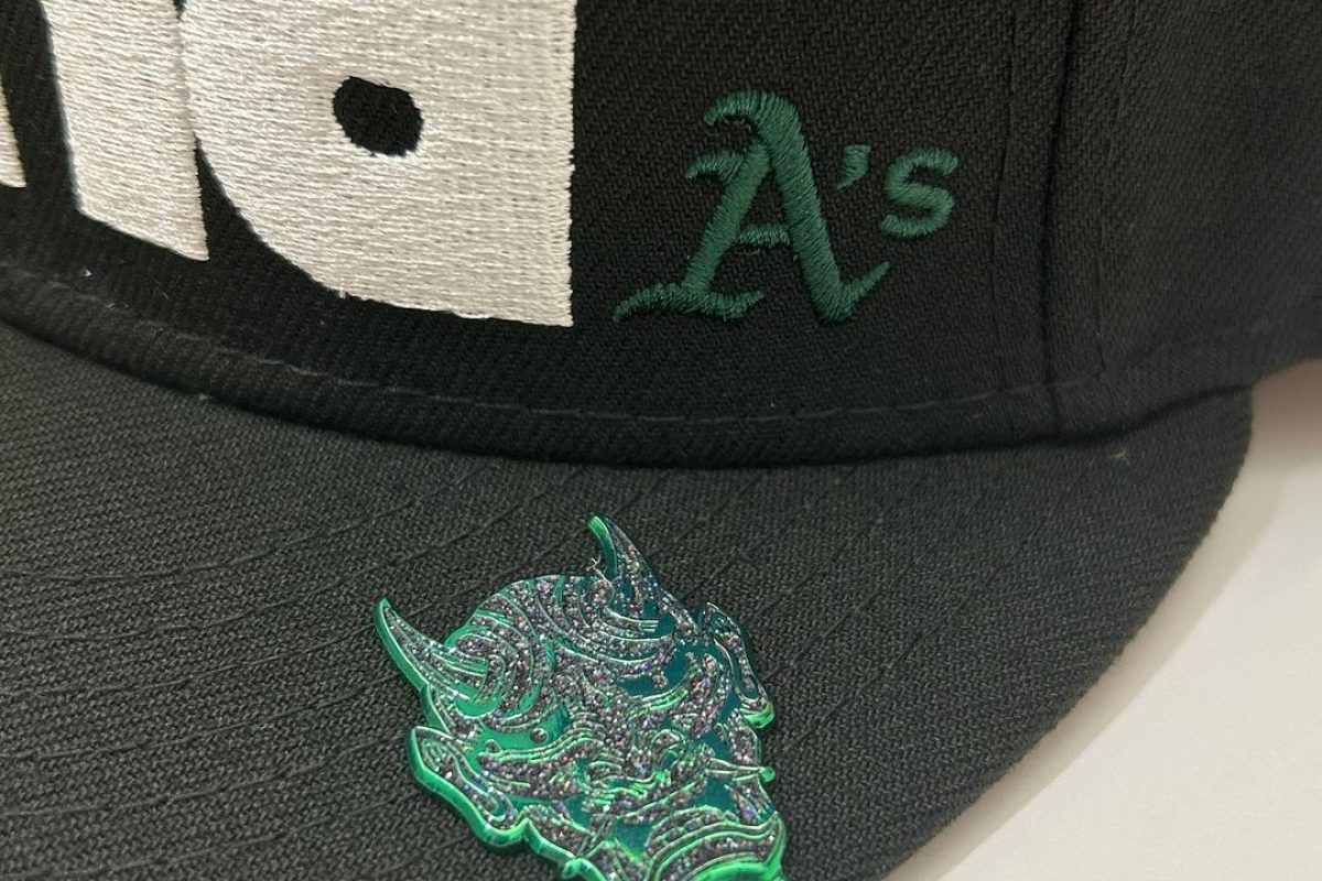 Detailed view of custom enamel hat pin design with multiple colors and finishes