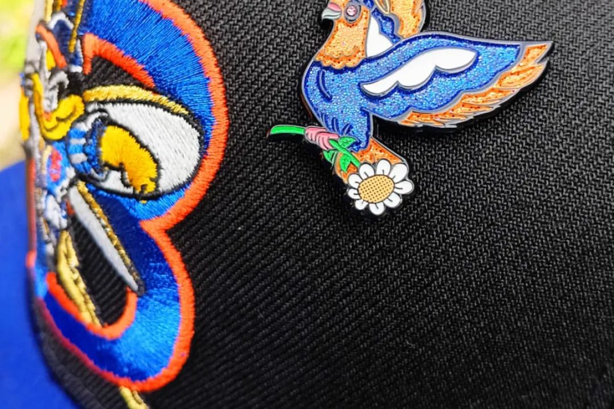 Detailed view of custom enamel hat pin design with multiple colors and finishes